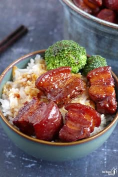 a bowl filled with rice and meat next to broccoli