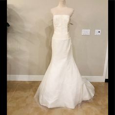 a white wedding dress on display in a room