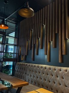 the restaurant is decorated with wood panels and leather booths, along with modern lighting fixtures