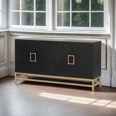 a black and gold sideboard in front of a window with white trim on it