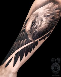 an eagle tattoo on the arm with black and grey ink, done by artist mark stott