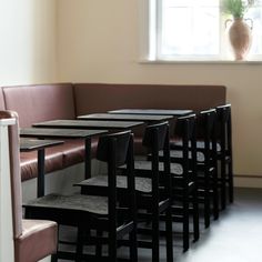 a row of black tables sitting next to each other in front of a brown couch