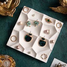 an assortment of jewelry is displayed on a tray