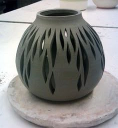 a gray vase sitting on top of a white table