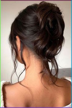 the back of a woman's head, with her hair in a low bun