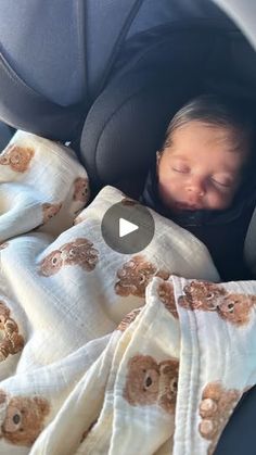 a baby sleeping in a car seat with a blanket over it's face and head