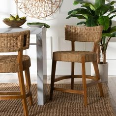 two chairs sitting next to each other in front of a table and potted plant