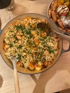 a pan filled with pasta and vegetables on top of a table next to other dishes