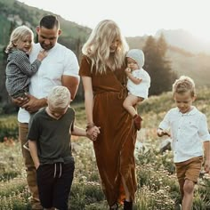 a group of people that are standing in the grass with some kids and an adult