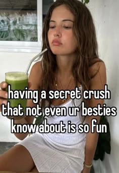 a woman sitting on a table holding a drink and looking at her cell phone with the caption having a secret crush that not even besties know about is so fun