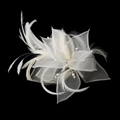 a white flower with pearls and feathers on a black background