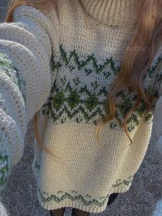 the back of a woman's sweater with green and white designs