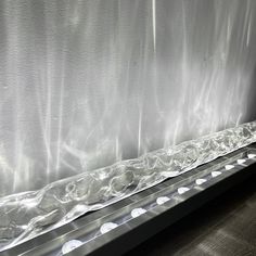 a window with plastic covering it and some lights on the windowsill in front of it