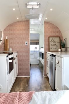 the interior of an rv with wood floors and pink wallpaper on the walls is shown