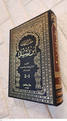 an arabic book is hanging on the wall in front of a white tile flooring