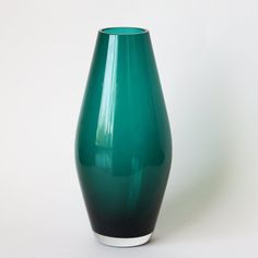 a green vase sitting on top of a white table