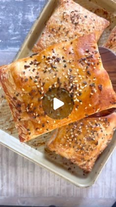 two square pieces of bread with sesame seeds on top, sitting in a baking dish