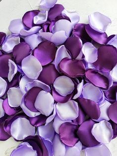 a pile of purple and white petals sitting on top of a table