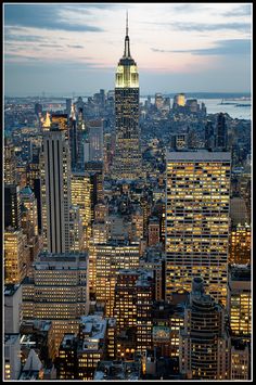 the empire building is lit up at night in new york city, ny with its lights on