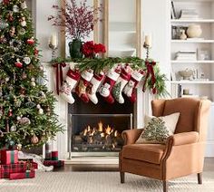 a living room decorated for christmas with stockings on the fireplace