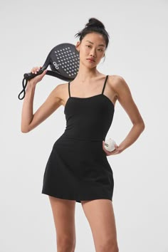 a woman holding a tennis racquet and ball