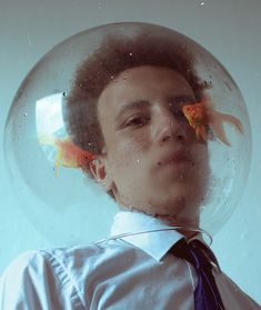 a young man with two goldfish in his hair, wearing a shirt and tie