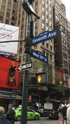 the street signs are clearly visible for everyone to see on this busy city street in new york