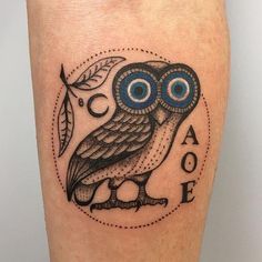 an owl with blue eyes and leaves on its leg is shown in this tattoo design