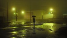 a person holding an umbrella standing in the rain at night with street lights behind them