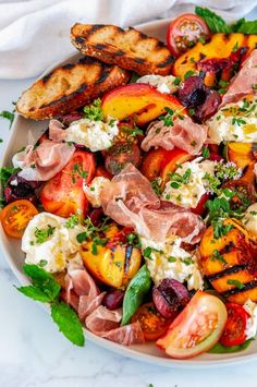 a white plate topped with lots of different types of food on top of a table