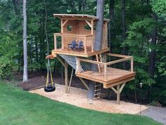 a tree house built into the side of a tree in a yard with lots of trees