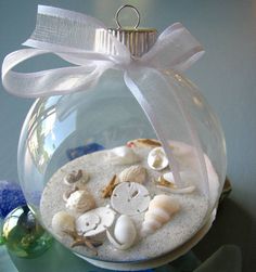 a glass ornament filled with sand and shells