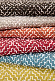 four different colored fabrics stacked on top of each other in various sizes and colors, all showing the same pattern