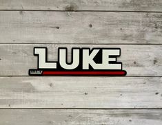 the word luke is written in black and red on a white wooden background with planks