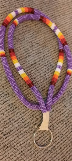 a purple lanyard with an orange, yellow and white stripe on it