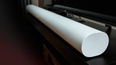 a white speaker sitting on top of a black table