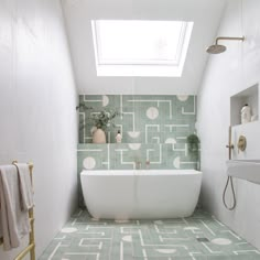 a white bath tub sitting under a skylight in a bathroom