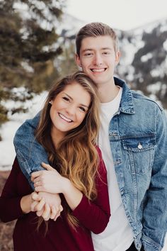 a young man and woman hugging in the snow