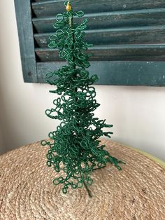 a small green christmas tree sitting on top of a table