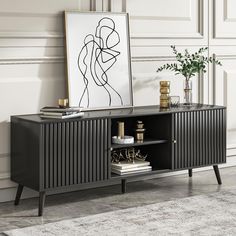 a black sideboard with an art piece on top