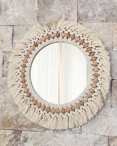 a round mirror hanging on the side of a stone wall