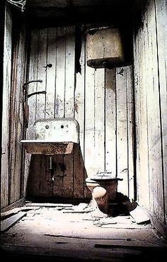 an old wooden bathroom with a sink and toilet