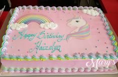 a pink birthday cake with a rainbow horse on it