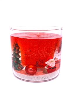 a glass filled with liquid and christmas decorations