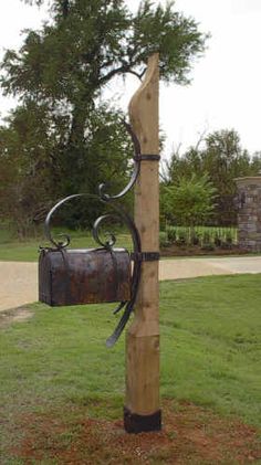 a mailbox attached to a wooden post in the grass