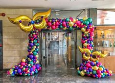 the entrance to an office decorated with balloons and streamers for mardi gras