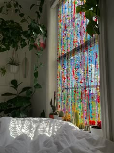 a bedroom with a bed, window and plants