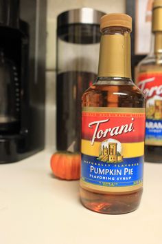 a bottle of torani pumpkin pie syrup sitting on top of a counter next to a microwave