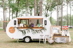 an old camper is decorated with greenery and other things for the guests to eat