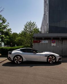 a silver sports car parked in front of a building